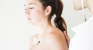 Femme avec des électrodes sur la poitrine, osculée par un médecin
