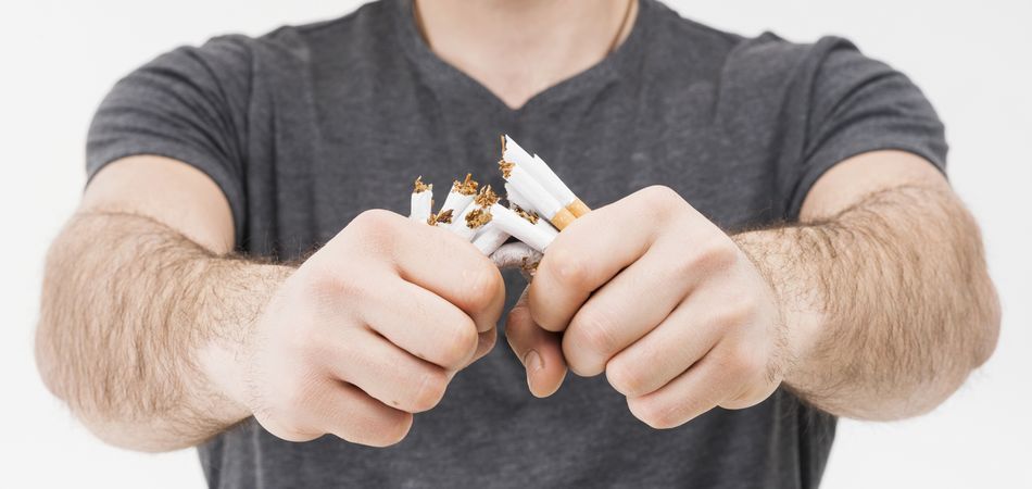 Un homme brise une poignée de cigarettes en deux