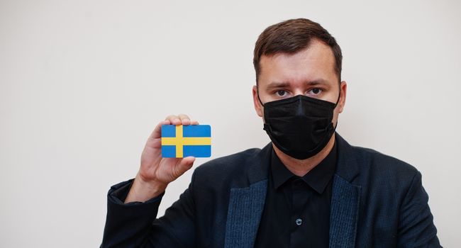 Homme tenant un drapeau suédois