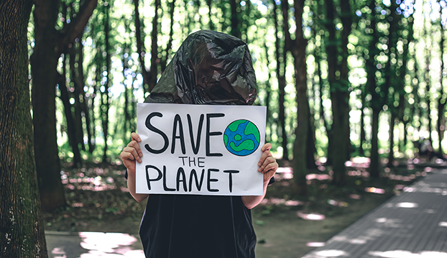 Une femme brandit un panneau disant "sauvez la planète"